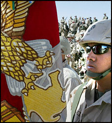 A Marine Corps color guard gathers with troops in the Kuwait desert. Photo taken February 6, 2003 (Reuters)